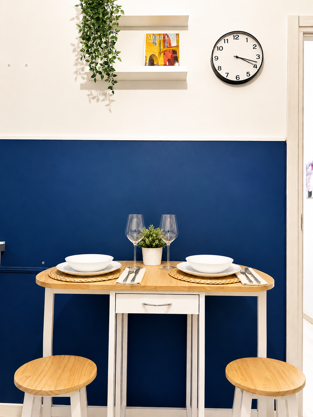 Dining nook with blue wall and styled table at BLUVIA RESIDENCES Spiral Apartment